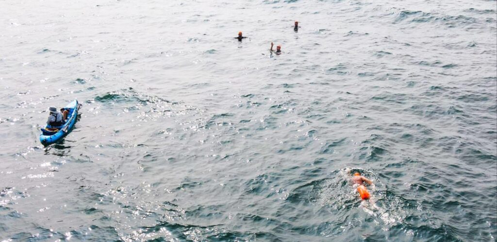 Hilly with orange buoy swimming towards Emily, Steve, Matt and Kevin